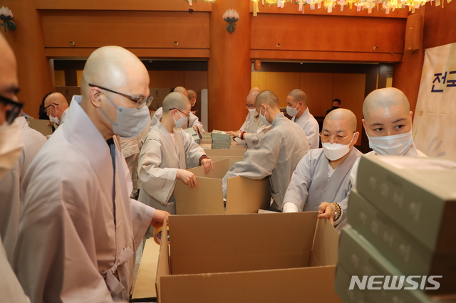 [서울=뉴시스]대한불교조계종 교역직 스님들과 종무원들이 21일 한국불교역사문화기념관에서 전국 2470여 사찰에 보낼 48만 매의 마스크를 포장했다.이 마스크는 전국 사찰에서 부처님오신날 법요식 진행과 소외된 이웃을 위해 사용된다. (사진=대한불교조계종 제공)2020.05.22 photo@newsis.com 