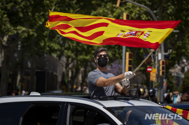 [마드리드=AP/뉴시스] 스페인 극우정당 복스(Vox)의 지지자가 23일 마드리드에서 열린 시위에 참석해 스페인 깃발을 흔들고 있다. 2020.5.24.