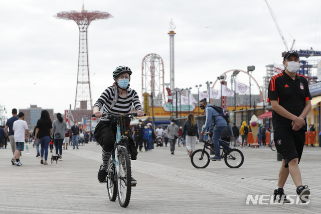 [AP/뉴시스] 뉴욕시 등 뉴욕주 대부분이 주민이동 금지의 자가감금 조치를 완화한 5월24일 메모리얼 데이 휴일을 앞두고 뉴욕시 대서양변 휴양지 코니 아일랜드에서 한 여성이 자전거를 타고 있다. 미국서 5월 말 현충일은 여름의 시작으로 친다. 2020. 6. 8. 