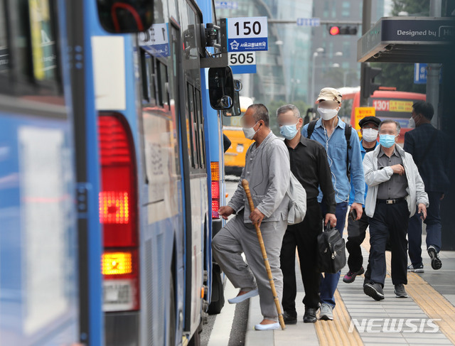 [서울=뉴시스] 박미소 기자 = 정부가 오는 26일부터 승객이 버스나 택시를 탈 때 운송사업자와 운수종사자가 마스크를 착용하지 않을 경우 관할 시·도지사가 개선 조치를 내리도록 한 25일 오후 서울 용산구 서울역 인근 버스 정류장에서 시민들이 마스크를 쓰고 버스에 탑승하고 있다. 2020.05.25.  misocamera@newsis.com