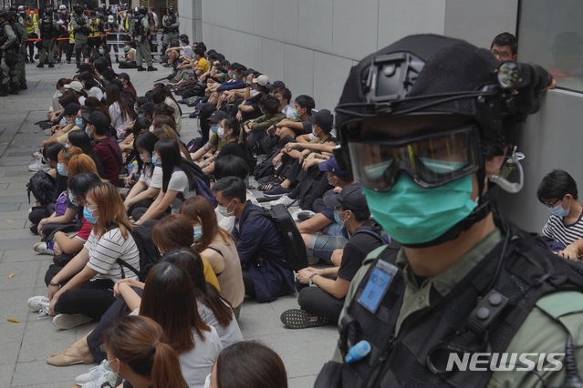 [홍콩=AP/뉴시스] 27일 홍콩 센트럴 지역에서 시위대가 연좌시위를 벌이고 있는 가운데 무장한 경찰관이 경계 근무를 서고 있다. 2020.05.27 