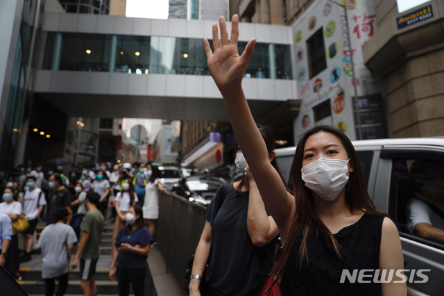 [홍콩=AP/뉴시스]27일 홍콩 입법부 앞에서 한 여성이 다섯 가지 요구사항을 의미하는 손가락을 펴 보이며 시위에 참여하고 있다. 중국 전국인민대표대회(전인대)가 처벌 대상을 대폭 확대하는 홍콩 국가보안법 수정안을 추진하는 가운데 홍콩 시위대는 입법부 청사 밖에서 이에 반대하는 시위를 벌이고 있다. 2020.05.27.