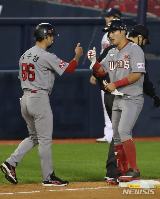 [서울=뉴시스] 조수정 기자 = 27일 오후 서울 잠실야구장에서 열린 2020 KBO 리그 SK와이번스 대 두산베어스 경기 5회초 2사 상황 SK 최지훈이 3루타를 날린 뒤 정수성 코치와 엄지를 맞대고 있다. 2020.05.27. chocrystal@newsis.com