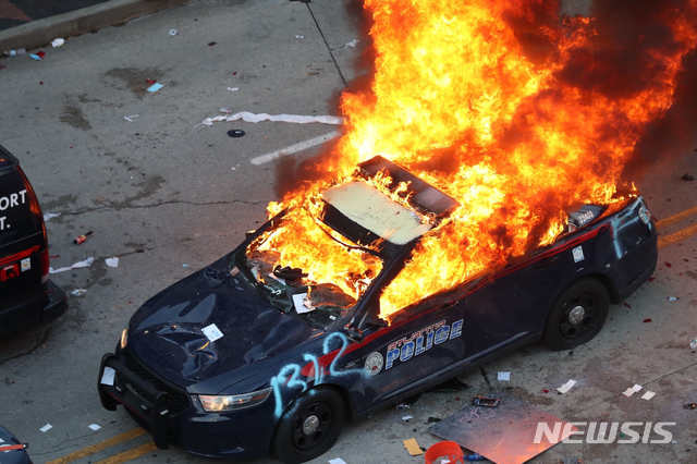 [애틀랜타= AP/뉴시스] 29일(현지시간) 미국 조지아주 애틀랜타에서 비무장 흑인 조지 플로이드가 백인 경찰에게 목이 짓눌려 사망한 사건에 대한 시위가 격화했다. 시위대가 조지아주 의사당으로 행진한 이후 CNN 본사 근처로 돌아온 상황에서 경찰차가 불에 타고 있다. 2020.05.30.