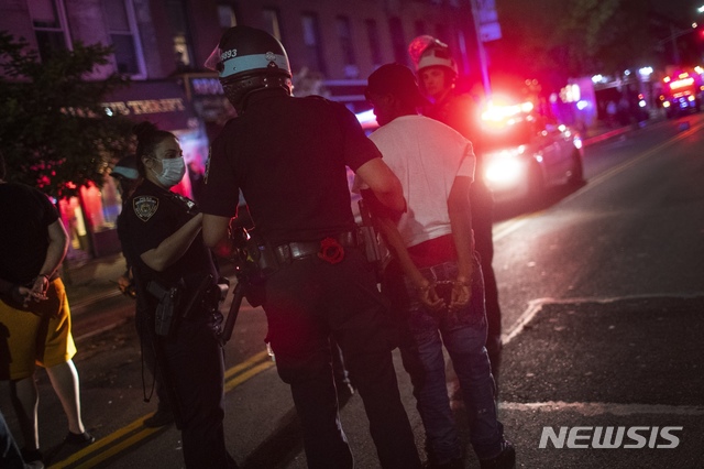 [브루클린=AP/뉴시스]29일(현지시간) 미 뉴욕 브루클린 바클리센터 인근에서 경찰에 의한 흑인 조지 플로이드 사망 사건 규탄 시위에 참석했던 한 시민이 경찰에 체포되고 있다. 2020.05.31.