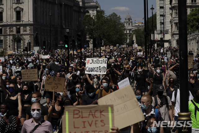 [런던=AP/뉴시스] 백인 경찰의 무릎에 목을 짓눌려 흑인 남성이 사망한 사건에 항의하는 시위가 영국 런던에서도 벌어졌다. 사진은 31일(현지시간) 런던 의회를 지나는 시위대의 모습. 2020.6.1.