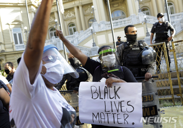 [리우데자네이루=AP/뉴시스]5월 31일(현지시간) 브라질 리우데자네이루 주 정부 청사 앞에서 최근 경찰의 빈민 지역 흑인들에 대한 폭력에 항의하는 시위가 열려 마스크를 쓴 사람들이 "흑인 생명도 소중하다"라는 손팻말을 들고 시위하고 있다. 이들 중 일부는 미국에서 경찰의 과잉 진압으로 숨진 흑인 남성 조지 플로이드가 호소했던 "숨을 쉴 수가 없다"(I can't breathe)라는 말을 외치며 시위를 벌였다. 2020.06.01.