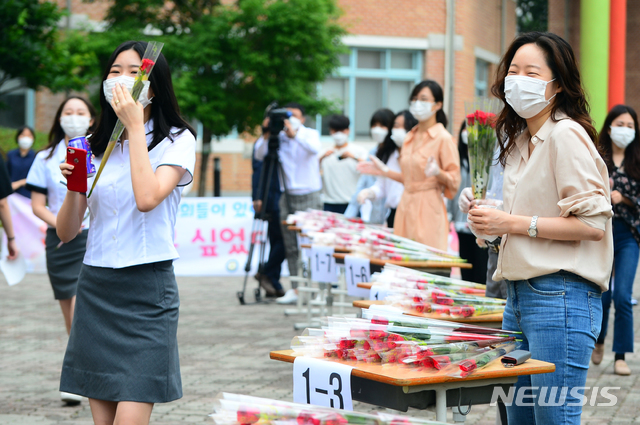 [청주=뉴시스] 인진연 기자 = 3차 순환등교가 시작된 3일 오전, 충북 청주 흥덕고등학교 교사들이 하복을 입고 첫 등교하는 신입생들에게 환영하는 의미를 담아 꽃을 건네고 있다. 이날 충북에서는 초 3·4, 중2, 고1 등 약 5만5000여 명이 첫 등교에 나섰다. 2020.06.03 inphoto@newsis.com 