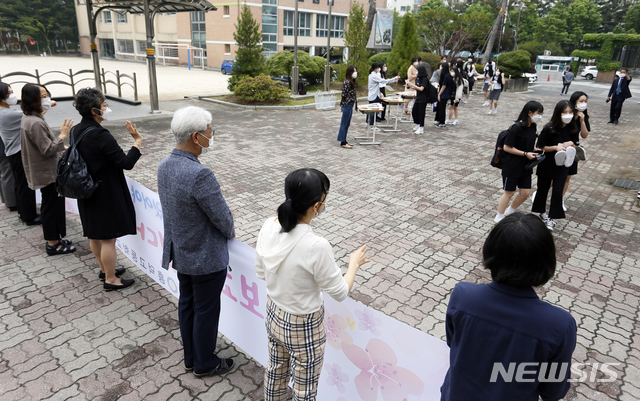 [청주=뉴시스] 인진연 기자 = 3차 순환등교가 시작된 3일 오전, 충북 청주 흥덕고등학교 교사들이 하복을 입고 첫 등교하는 신입생들에게 반갑게 손을 흔들고 있다. 이날 충북에서는 초 3·4, 중2, 고1 등 약 5만5000여 명이 첫 등교에 나섰다. 2020.06.03  inphoto@newsis.com 