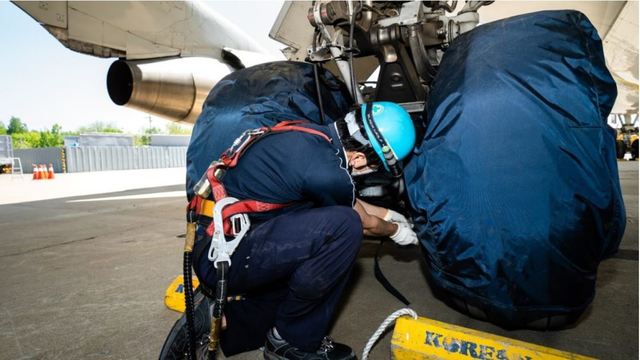 [서울=뉴시스] 대한항공 B747-400 항공기 타이어에 덮개를 씌우고 있는 정비사. 사진 대한항공