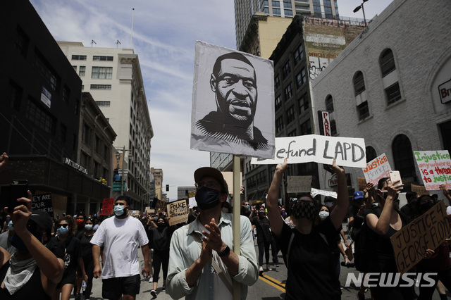 [로스앤젤레스= AP/뉴시스] 지난 달 25일 미니애폴리스에서 경찰관에게 살해된 조지 플로이드의 대형사진을 든 LA시위대가 2일(현지시간) 거리를 행진하고 있다.   