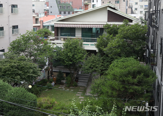 [서울=뉴시스] 조수정 기자 = 여성가족부가 정의기억연대(정의연) 운영 일본군 위안부피해자 쉼터 '평화의 우리집' 운영 종료 가능성을 내비친 12일 서울 마포구 '평화의 우리집'에서 한 관계자가 빨래를 걷은 뒤 내부에서 정리를 하고 있다. 여가부는 12일 정부서울청사에서 긴급 기자간담회를 통해 길원옥 할머니 퇴소로 현재 거주하고 계신 할머니가 없어 운영이 어려울 것으로 판단돼 사업을 종료해야 할 것으로 보인다고 밝혔다. 2020.06.12. chocrystal@newsis.com