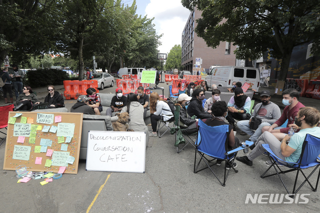 [ 시애틀( 미 워싱턴주)= AP/뉴시스]시애틀 시내의 "의사당앞 농성금지구역" (CHOP. Capitol Hill Occupied Protest)에서 농성과 대화를 하고 있는 시위대원들. 