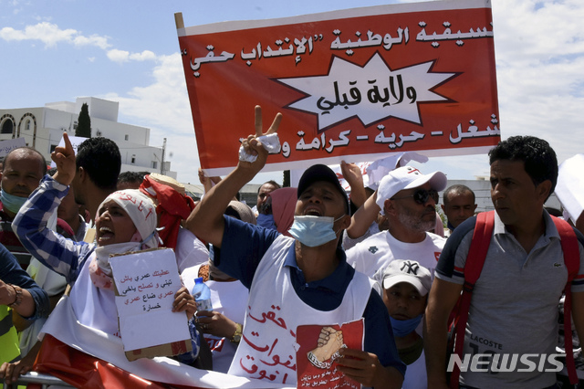[튀니스(튀니지)=AP/뉴시스]대학을 졸업하고도 일자리 부족으로 실업에서 벗어나지 못하고 있는 튀니지 청년들이 지난 6월17일 수도 튀니스에서 "국가가 삶을 잃어버리게 만들고 있다"고 쓰인 플래카드를 들고 시위를 벌이고 있다. '아랍의 봄'을 불러온 튀니지에서 13일 한 남성의 담배를 파는 키오스크에서 잠다던 중 키오스크를 철거하려는 불도저에 깔려 숨지는 사건이 발생, 시민들의 폭동이 일어나면서 2010년 아랍의 봄이 시작된 노점 청년의 극단적 선택과 비교되고 있다. 2020.10.14  