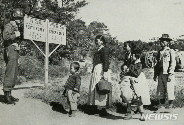 [서울=뉴시스] 1947년 5월 38선 표지판 앞에 도착한 월남 가족을 미군 헌병이 바라보고 있다. (사진=미국 국립문서기록청) 2020.06.21. photo@newsis.com (* 위 사진은 재배포, 재판매, DB 및 활용을 금지합니다)