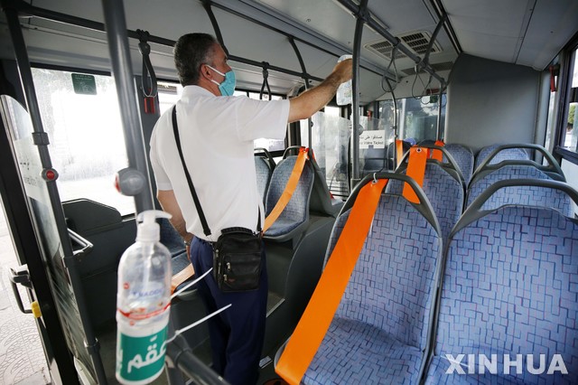 [ 알제= 신화/뉴시스] 알제리의 수도 알제 당국의 한 보건요원이 6월중순부터 운행재개된 시내 버스 안을 소독하고 있다. 