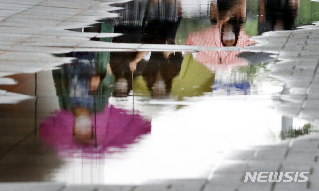 [인천=뉴시스] 이종철 기자 = 본격적인 장마가 시작된 지난 24일 오후 인천시 남동구 터미널사거리에서 여학생들이 우산을 쓰고 도로 물웅덩이 옆을 지나가고 있다. 2020.06.24. jc4321@newsis.com