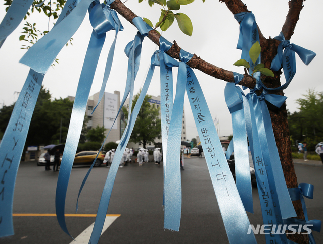 [서울=뉴시스] 조수정 기자 = 국제중학교 지정 취소 처분을 받은 대원·영훈국제중학교 학부모들이 25일 오전 서울 종로구 신문로 서울시교육청 앞에서 집회를 열고 취소 철회를 촉구하는 가운데 영훈국제중학교를 상징하는 하늘색 리본이 걸려 있다. 이 리본은 학부모들이 매달았다. 서울시교육청은 이날 대원·영훈국제중학교의 입장을 듣는 청문 절차를 진행한다. 2020.06.25. chocrystal@newsis.com