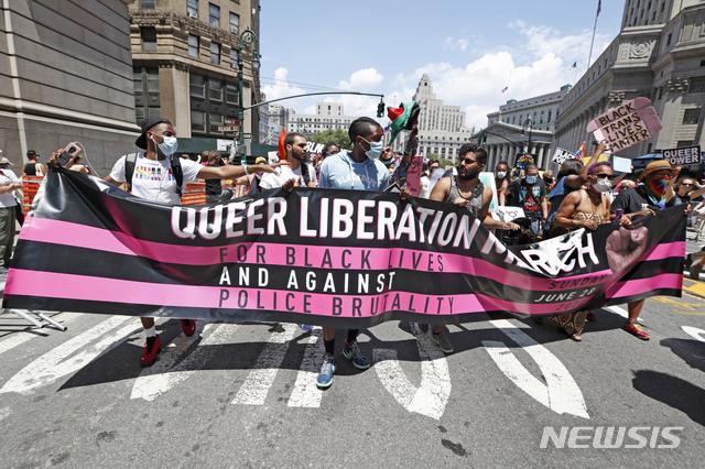 [ 뉴욕= AP/뉴시스] 뉴욕 프라이드 행진 59주년을 맞아 지난 28일(현지시간) 뉴욕 맨해튼 거리에서 마스크 쓴 참가자들이 구호를 외치며 행진하고 있다. 2020.06.30