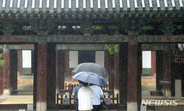 [전주=뉴시스] 김얼 기자 = 전북지역에 정체전선의 영향으로 비가 내린 29일 전북 전주시 전주한옥마을 경기전에서 우산을 쓴 관광객들이 발걸음을 재촉하고 있다. 2020.06.29. pmkeul@newsis.com