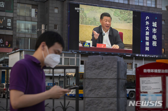 [베이징=AP/뉴시스] 6월30일(현지시간) 중국 베이징에서 한 남성이 시진핑 중국 국가주석이 발언하는 장면을 보여주는 전광판 앞을 지나가고 있다. 2020.07.01.