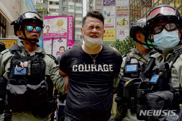 [홍콩=AP/뉴시스] 1일 홍콩 도심에서 경찰들이 한 시위자를 연행하고 있다. 홍콩보안법이 이날부터 본격 시행된 가운데 이 법을 근거로 한 첫 번째 체포 사례가 나왔다. 2020.07.01 