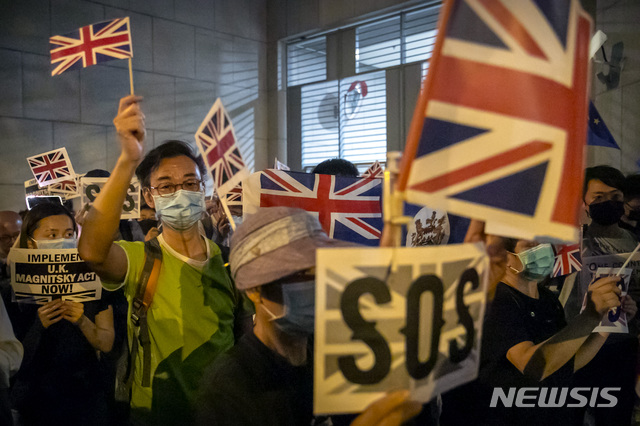 [홍콩=AP/뉴시스] 영국이 2021년 1월부터 5년 동안 홍콩 시민 최대 100만명을 수용하겠다고 밝혔다. 사진은 지난해 10월 반(反)중국 시위 중 홍콩 시민들이 영국 국기를 흔드는 모습. 2020.10.23.