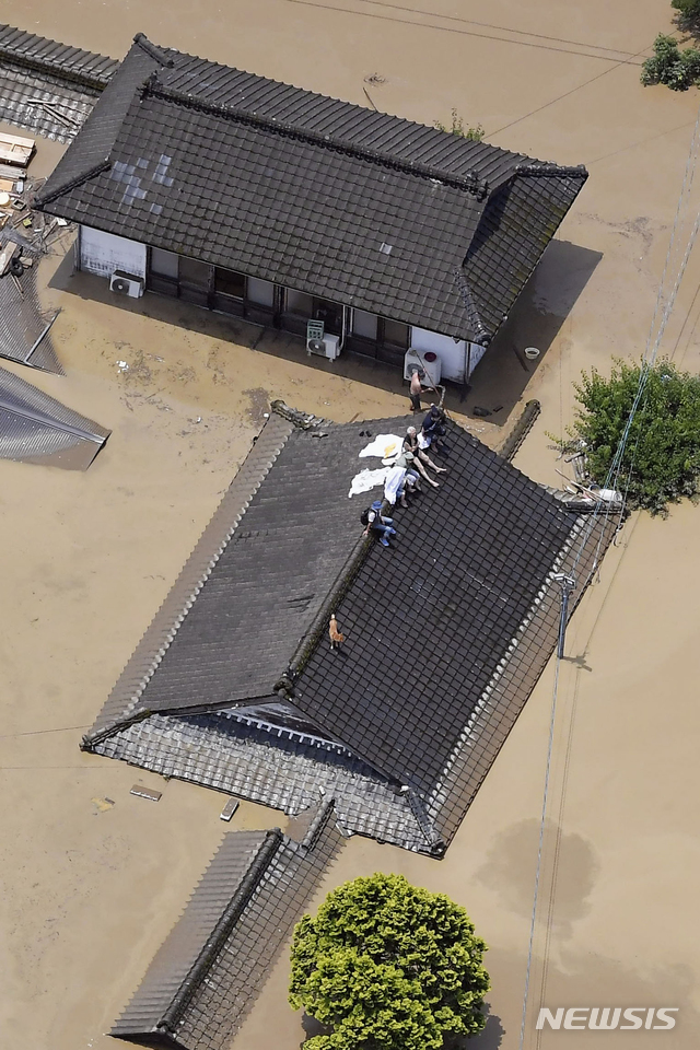[히토요시(일본 구마모토현)=AP/뉴시스] 4일 일본 규슈지역 구마모토(熊本)현 히토요시(人吉)시에서 폭우로 가옥이 물에 잠기자 주민들이 지붕 위에 올라가 구조를 기다리고 있다. 2020.07.04