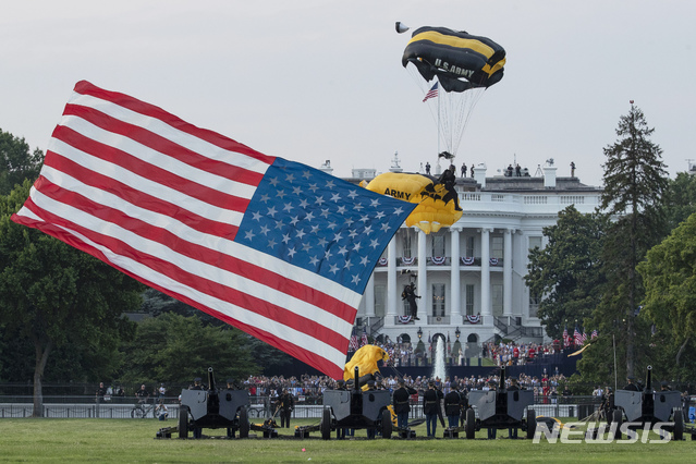 [워싱턴 =AP/뉴시스] 트럼프 대통령 부부의 7월4일 백악관 독립기념일 저녁 행사가 열린 백악관 남쪽 뜰에서 수백명의 초청객들과 트럼프부부가 미군 비행단의 성조기 낙하 게양식을 바라보고 있다.  