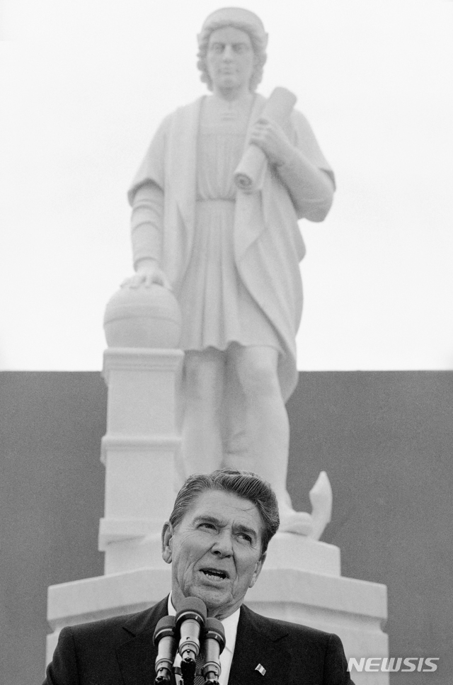 [볼티모어=AP/뉴시스] 미국 메릴랜드주 볼티모어에서 4일(현지시간) 시위대가 크리스토퍼 콜럼버스 조각상을 끌어내려 바다에 빠트렸다. 사진은 1984년 10월 9일 볼티모어를 방문한 로널드 레이건 당시 대통령이 콜럼버스 조각상 제막식에서 연설하던 모습. 2020.07.05