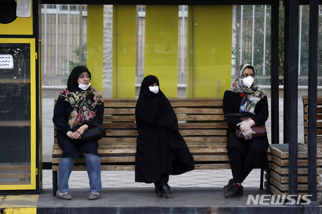 [잔잔=AP/뉴시스] 이란 수도에서 서쪽으로 330㎞ 떨어진 도시에서 5일 주민들이 마스크를 챙겨 쓰고 버스정거장에 앉아 있다. 이란은 최근 사망자가 급증하자 공공교통 탑승시 마스크 착용을 의무화하고 또 마스크를 쓰지 않는 사람한테는 공공서비스를 하지 말라는 지시가 내려졌다. 2020. 7. 5