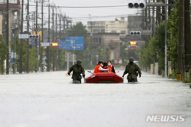 [후쿠오카=AP/뉴시스]7일 기록적인 폭우가 쏟아진 일본 규슈 지역 후쿠오카현 오무타무라에서 자위대원들이 고무보트를 통해 주민들을 구조하고 있다. 2020.07.07.