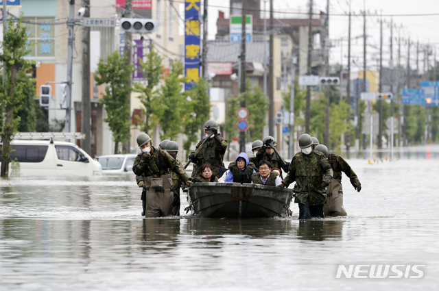 [오무타=AP/뉴시스]2020년 7월7일 기록적인 폭우가 쏟아진 일본 규슈 지역 후쿠오카현 오무타에서 일본 자위대원들이 고무보트로 주민들을 구조하고 있다. 2020.07.07.