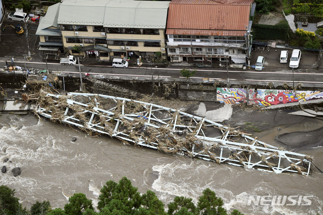 [히타=AP/뉴시스] 일본 오이타현 히타에 지난 8일 기록적인 폭우로 불어난 강물에 끊긴 다리 구조물이 쓰러져 있다. 2020.07.09 