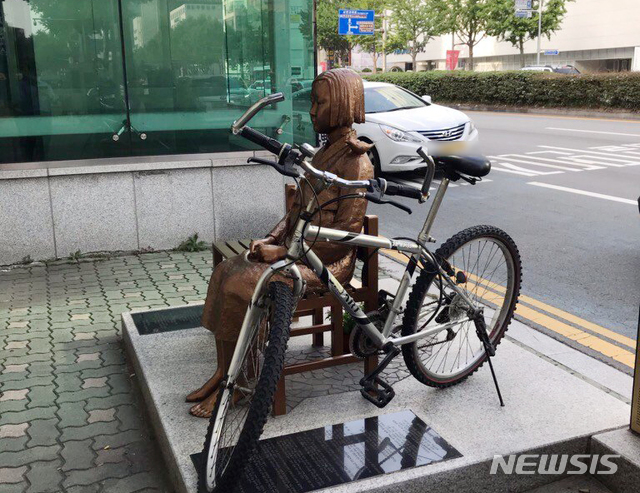 [부산=뉴시스] 8일 오후 부산 동구 일본총영사관 앞에서 20대 후반으로 추정되는 남성이 평화의 소녀상에 자전거를 자물쇠로 묶고 달아났다. (사진=소녀상을지키는부산시민행동 제공) 