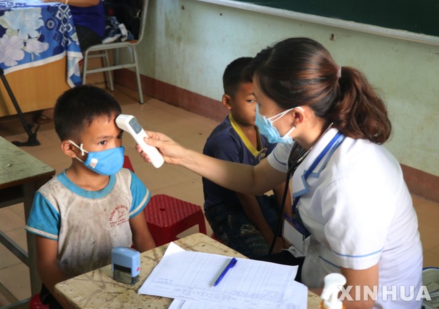 [닥락=신화/뉴시스]베트남에서 디프테리아가 확산돼 60명 이상이 감염되고 최소 3명이 사망했다 .사진은 8일 베트남 닥락 성의 한 마을에서 의료진이 어린이들의 체온을 재고 있는 모습. 2020.07.09