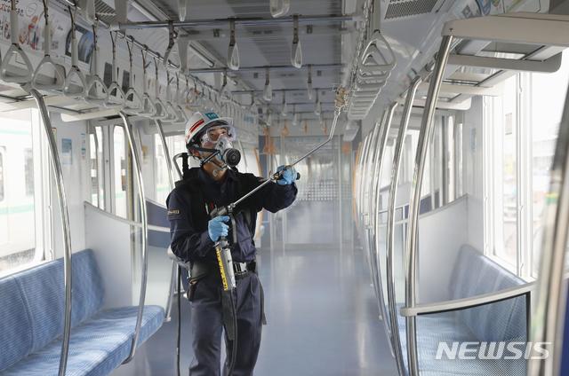 [도쿄=AP/뉴시스]지난 9일 방호복을 입은 일본 도쿄 메트로 직원이 지하철 차고에서 지하철 객실에 항바이러스 코팅을 하기 위해 화학물질을 뿌리고 있다. 이 회사는 8월 중순까지 2720대의 차량을 모두 소독할 계획이라고 전했다. 2020.07.09.