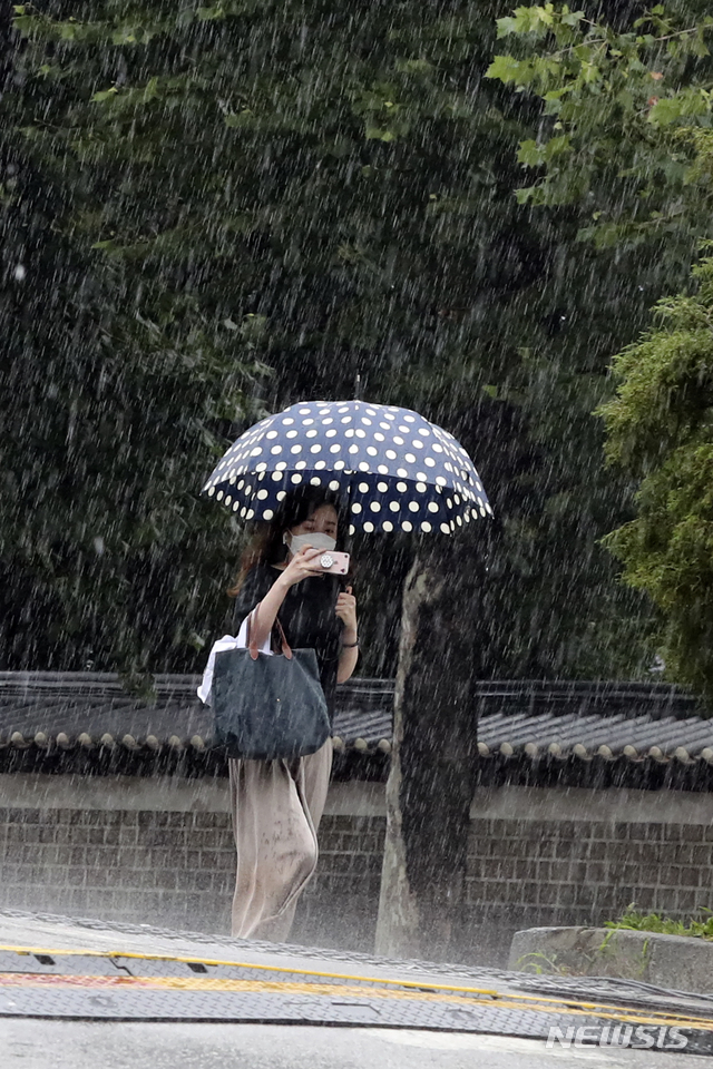 [서울=뉴시스] 최진석 기자 = 전국 곳곳에 장맛비가 내리고 있는 지난 10일 오전 서울 종로구 창경궁 인근에서 시민이 우산을 쓴 채 비를 맞으며 발걸음을 재촉하고 있다. 2020.07.10.myjs@newsis.com