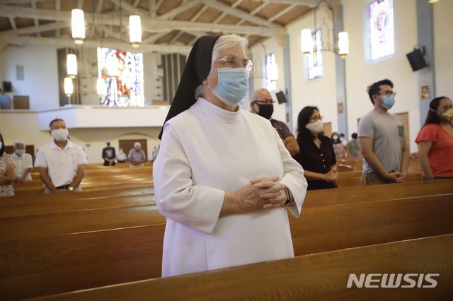 [캘리포니아=AP/뉴시스]12일(현지시간) 미국 캘리포니아 샌 가브리엘의 한 교회에서 수녀가 신종 코로나바이러스 감염증(코로나19) 예방을 위한 마스크를 쓴 채 예배를 하고 있다. 2020.07.12.