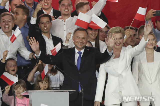 [풀투스크=AP/뉴시스]12일(현지시간) 폴란드 풀투스크에서 안제이 두다 대통령(가운데)이 부인과 함께 지지자들에게 손을 흔들고 있다. 그는 이날 치러진 대선 출구조사 결과 지지율 1위를 달렸다. 2020.07.12.