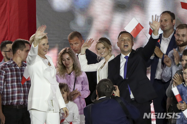 [풀투스크=AP/뉴시스]안제이 두다(가운데) 폴란드 대통령이 12일(현지시간) 폴란드 풀투스크에서 부인 안나 코모로프스카, 딸 킨가와 함께 지지자들에게 손을 흔들고 있다. 2020.07.12.