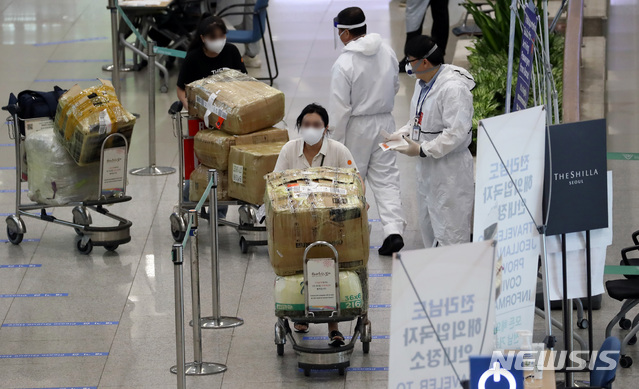 [인천공항=뉴시스] 이영환 기자 = 신종 코로나바이러스 감염증(코로나19) 해외유입 신규 확진자가 증가하고 있는 14일 오전 인천국제공항 제1여객터미널에서 입국한 승객들이 안내를 받고 있다. 중앙방역대책본부는 14일 0시 기준으로 신규 확진자가 33명 늘었으며 이중 해외유입이 19명, 지역 발생 14명이라고 밝혔다. 2020.07.14.  20hwan@newsis.com