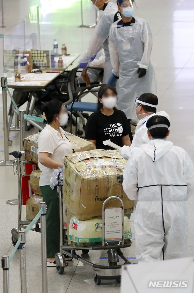 [인천공항=뉴시스] 이영환 기자 = 신종 코로나바이러스 감염증(코로나19) 해외유입 신규 확진자가 증가하고 있는 14일 오전 인천국제공항 제1여객터미널에서 입국한 승객들이 안내를 받고 있다. 중앙방역대책본부는 14일 0시 기준으로 신규 확진자가 33명 늘었으며 이중 해외유입이 19명, 지역 발생 14명이라고 밝혔다. 2020.07.14. 20hwan@newsis.com