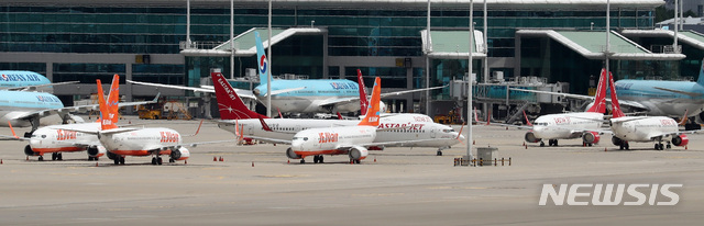 [인천공항=뉴시스] 이영환 기자 = 제주항공이 이스타항공에 통보한 인수합병(M&A) 선결 조건 이행 시한을 하루 앞둔 14일 오전 인천국제공항 여객터미널에 제주항공 비행기와 이스타항공 비행기가 멈춰 서 있다. 항공업계에 따르면 제주항공은 지난 1일 이스타항공에 "영업일 기준 10일 안에 미지급금 해소 등 선결조건을 이행하지 않을 시 계약을 파기할 수 있다"는 내용을 담은 공문을 보냈으며 이스타항공이 15일까지 250억원가량의 체불임금을 포함한 1700억원대의 미지급금을 갚아야 한다는 의미다. 2020.07.14. 20hwan@newsis.com