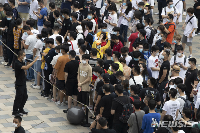 [베이징=AP/뉴시스]17일 중국 베이징 싼리툰 거리에 개점한 애플의 플래그십 매장 앞에서 이곳 직원이 몰려든 애플 팬들을 통제하고 있다. 중국 국가통계국은 코로나19 여파로 지난 1분기 경제성장률이 마이너스 6.8%까지 추락했던 중국 경제가 2분기에는 지난해 같은 기간보다 3.2% 반등했다고 발표했다. 2020.07.17. 