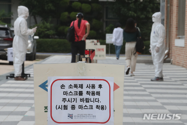 [서울=뉴시스]김명원 기자 = 보건직 공무원 필기시험 18일 오전 서울 송파구 올림픽로 잠실중학교에서 열린 가운데 수험생들이 사회적 거리두기, 손소독 및 발열체크를 받으며 입실하고 있다. 49명을 선발하는 이번 시험은 8월 8일(토) 면접시험에 이어 8월 21일(금)에 최종합격자를 보건복지부 홈페이지에 발표할 예정이다. 다만 모든 일정은 코로나19 상황에 따라 연기(조정)될 수 있다. 2020.07.18.  kmx1105@newsis.com 