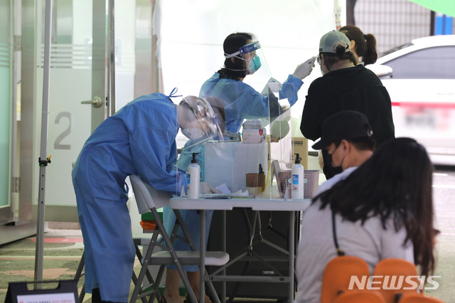 [서울=뉴시스]이윤청 기자 = 서울 강서구의 한 데이케어센터에서 20일 오전 8명이 추가 확진판정을 받아 서울에서 총 11명이 이날 추가 확진판정을 받았다. 20일 서울 강서구 보건소에 설치된 컨테이너형 워킹스루 선별진료소에서 시민들이 코로나19 검사를 받고 있다. 2020.07.20.  radiohead@newsis.com