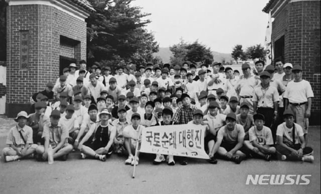 [증평=뉴시스]강신욱 기자 = 형석중학교50년사편찬위원회는 올해 개교 50주년을 맞아 학교 태동과 발전의 역사를 담은 '형석중 50년사'를 펴냈다. 사진은 2003년 교문 앞에서 기념사진을 찍은 국토순례대행진 참가 학생들. (사진=형석중 제공) 2020.07.21. photo@newsis.com