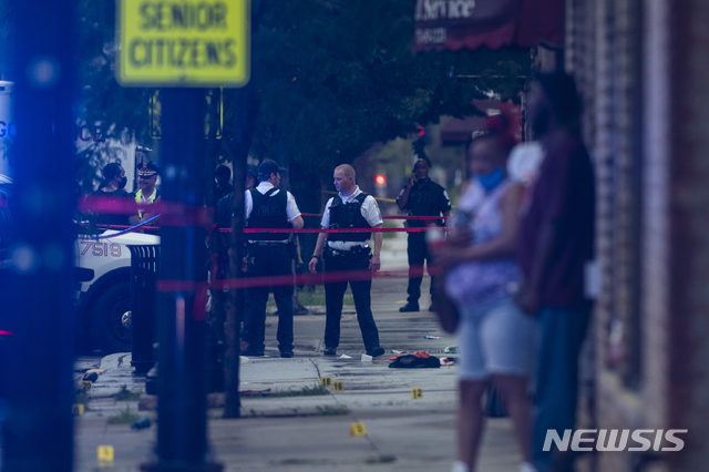 [시카고=AP/뉴시스]시카고 경찰이 21일(현지시간) 총격 사건이 발생한 그레셤 지역에서 현장 조사를 하고 있다. 이날 이 지역 장례식장 인근에서 총격이 발생해 최소 14명이 부상을 입었다. 2020.07.22.