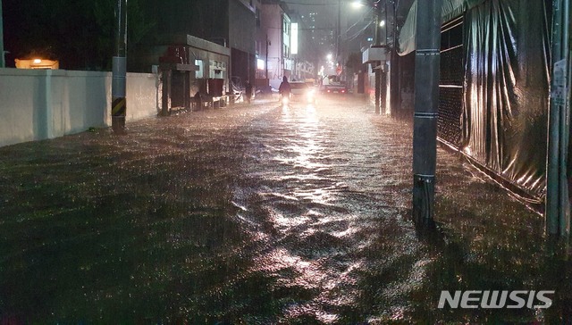 [부산=뉴시스] 하경민 기자 = 부산지역에 호우경보가 발효된 23일 오후 수영구의 한 주택가 이면도로가 침수돼 시민과 차량들이 힘겹게 이동하고 있다. 2020.07.23. yulnetphoto@newsis.com